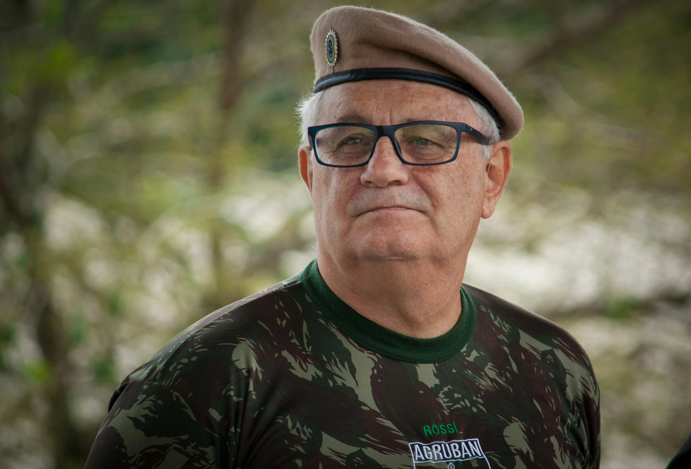 an old man in camouflage clothing with a military hat