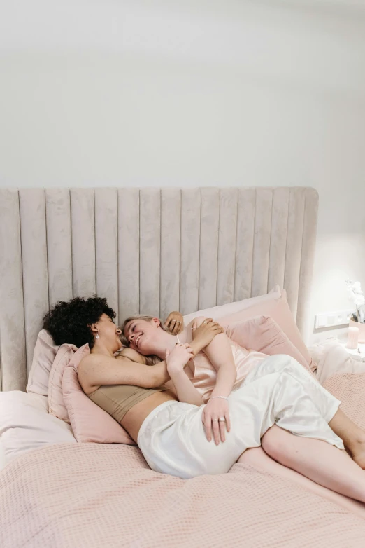 two women are kissing on a bed