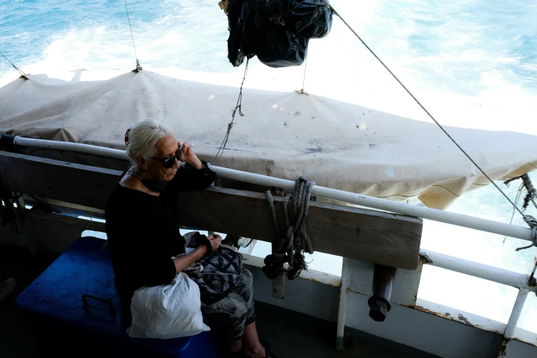 the woman is talking on the phone while on her boat