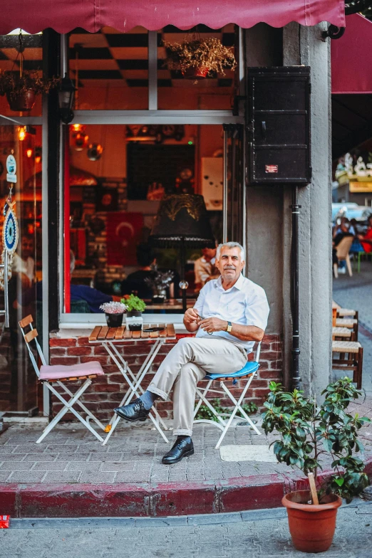 an older man sitting outside on a chair with his child