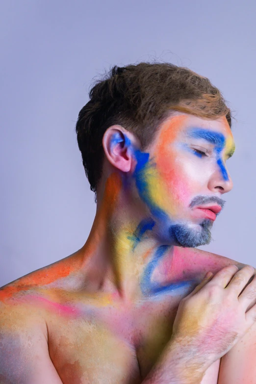 a man with his arm crossed covered in colored powder