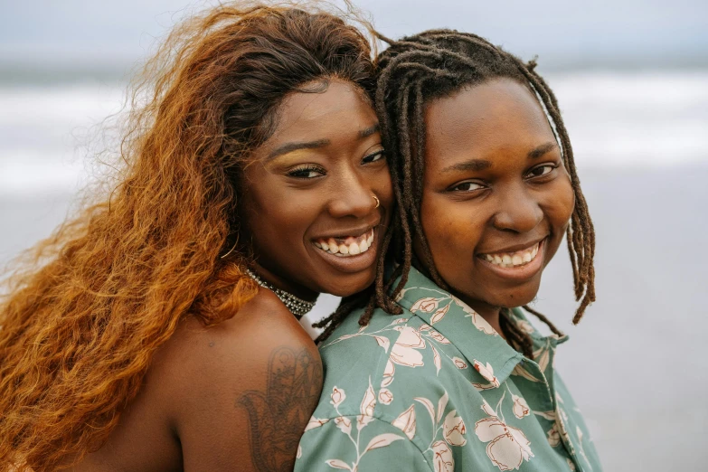 two young women in front of the ocean