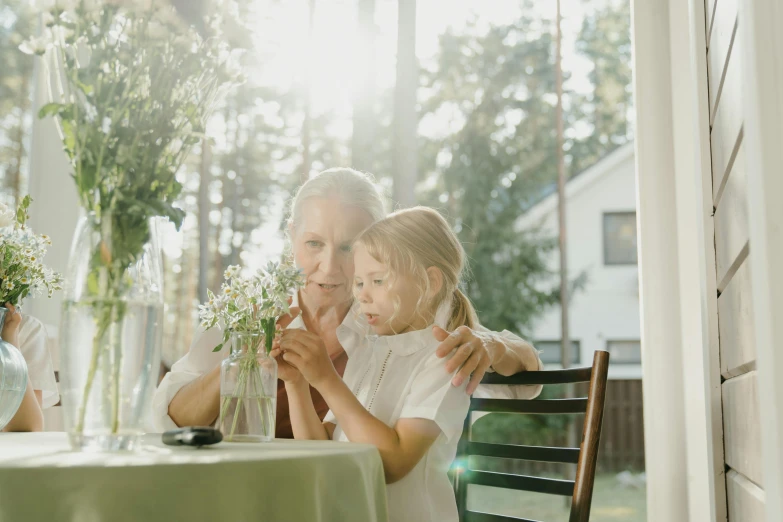 the little girl and the older woman are sitting at the table