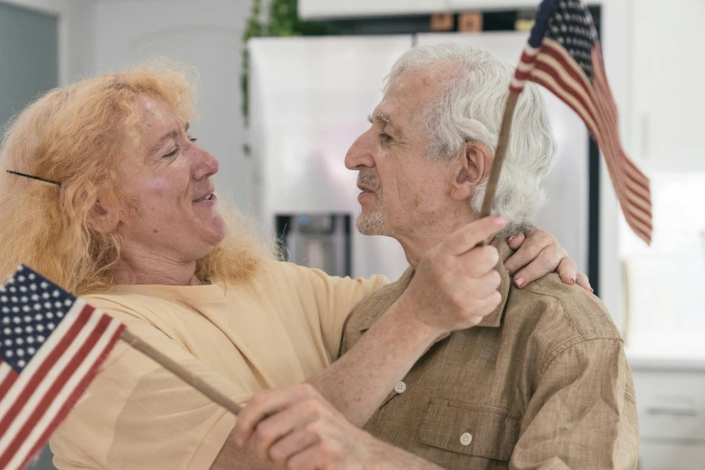 a woman holding an american flag and man