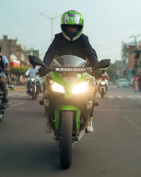 a man wearing a helmet is riding his green motorcycle