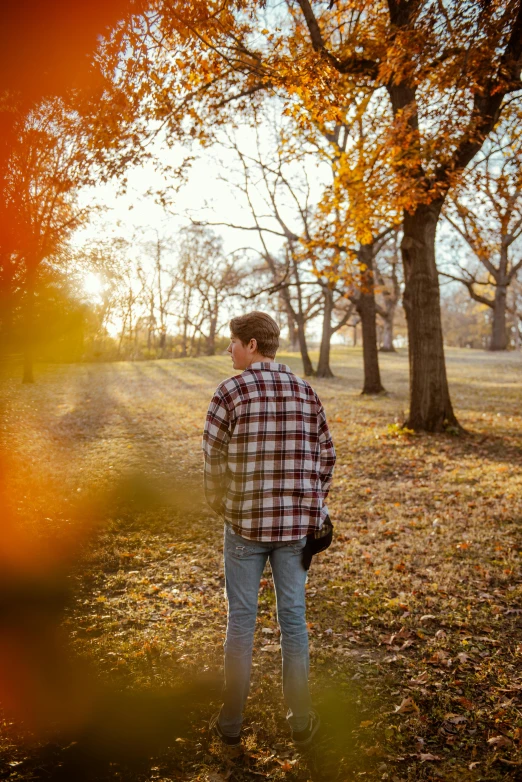 a man standing in a field near trees