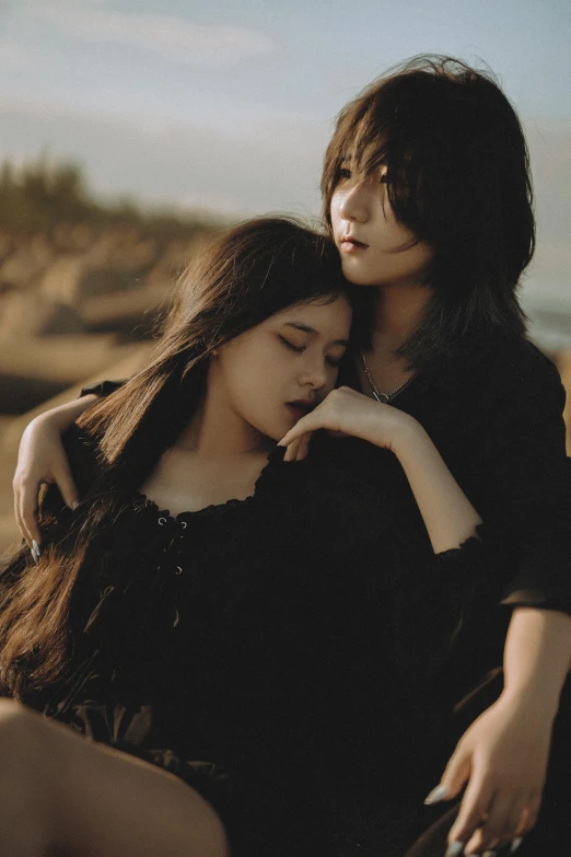 two asian women in black dress are sitting down