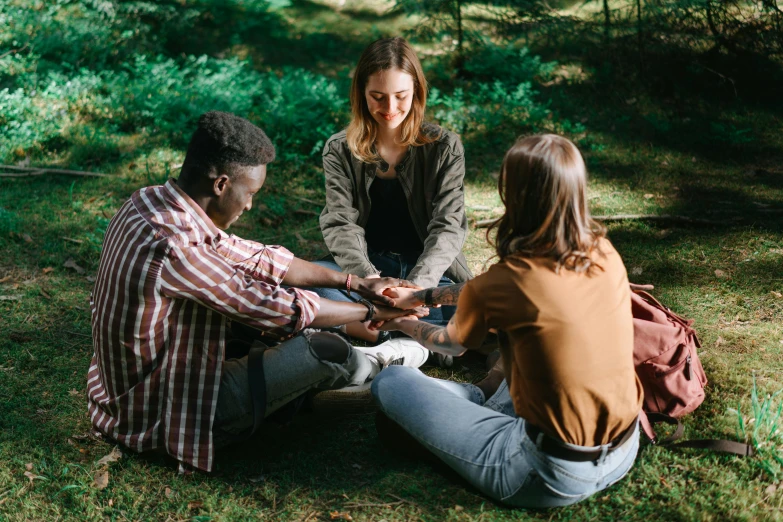 four young adults engaged in a conversation in the forest