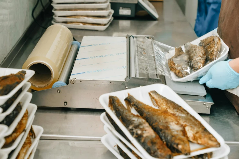 a baker placing food into packages onto plastic trays