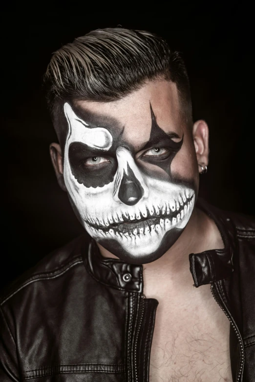 a man in white makeup wearing a skull face mask