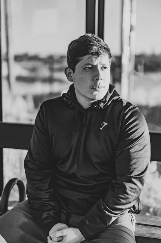 a black and white po of a young man sitting on a bench