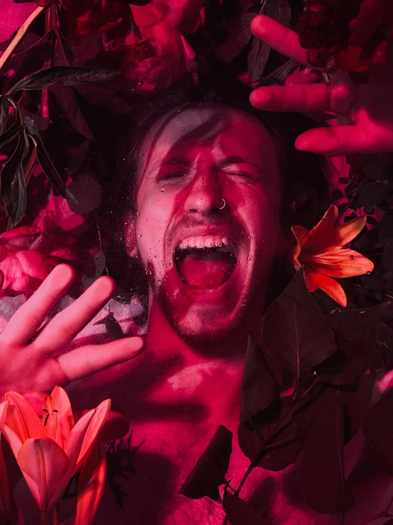 a shirtless man with a bunch of roses around him