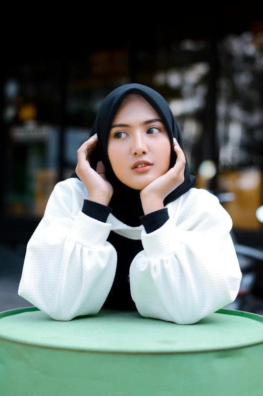 a woman sitting at a table talking on a cell phone