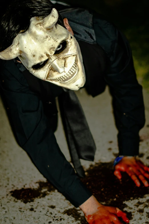 a man is wearing an evil mask while riding on his skateboard