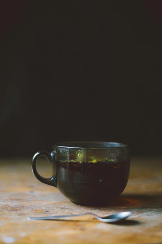 a glass cup filled with tea sitting on top of a table