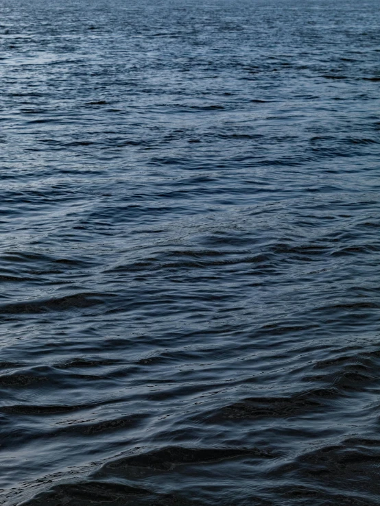 an ocean with a large body of water and a few boats on it