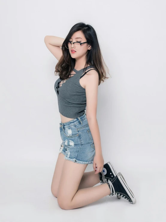 an asian woman wearing glasses and shorts poses for the camera