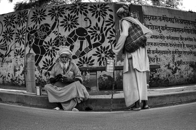 two people on the street near some art work