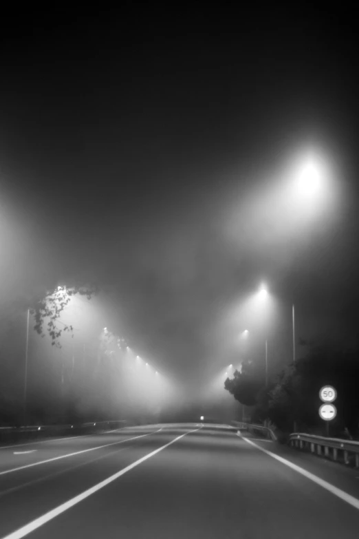 a dark night with fog hanging low over the road