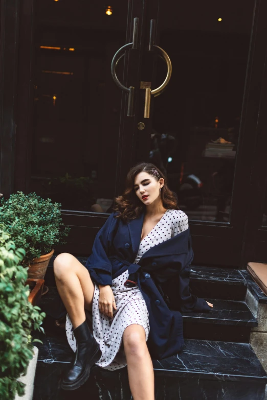 a woman sitting on the steps in front of a building