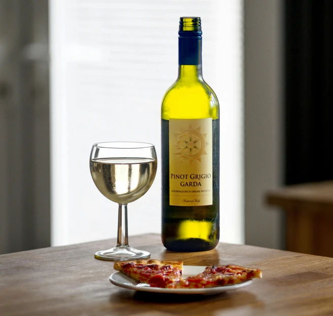 a wine bottle on a table with some food and a glass of wine