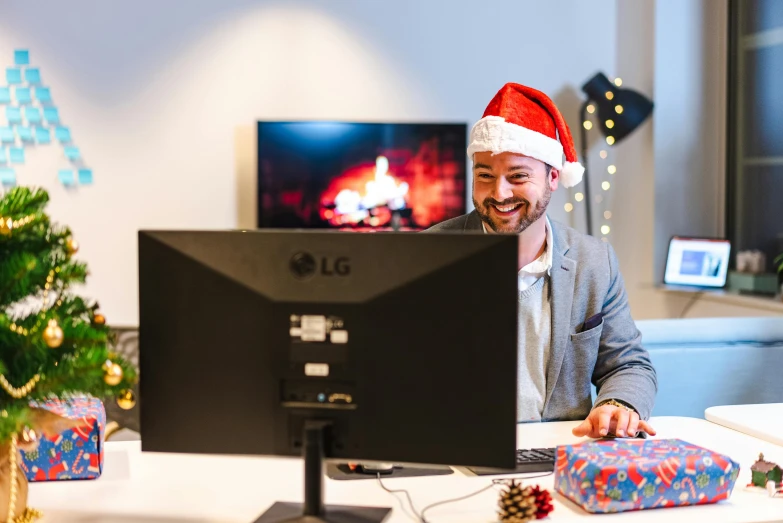 man dressed as santa claus working at computer