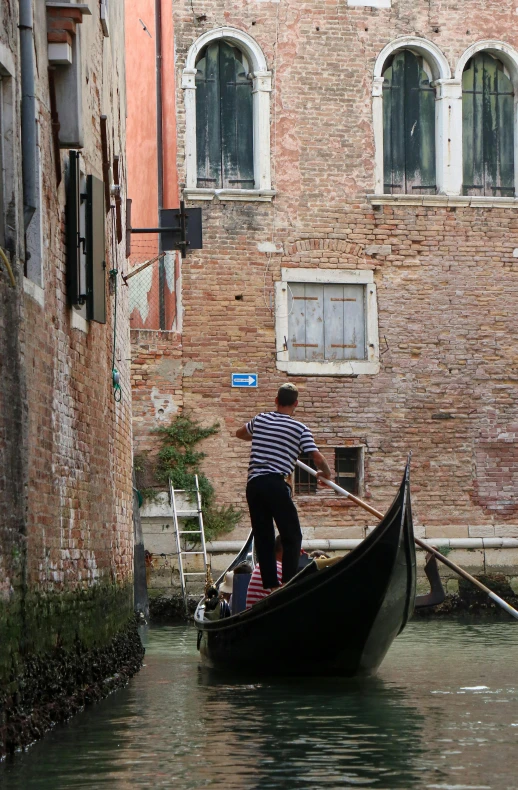 a man riding in a small boat on a canal