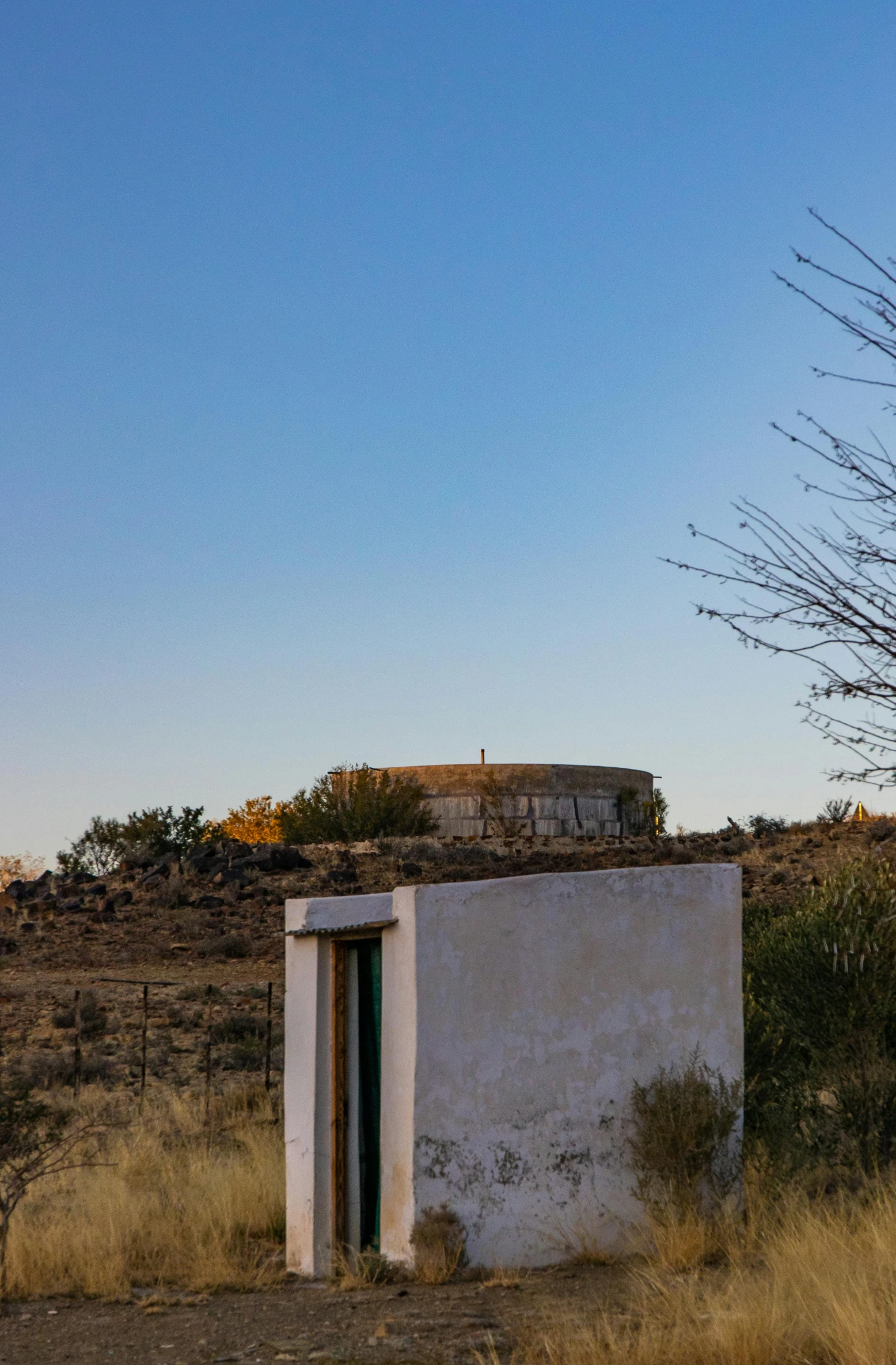 a building sitting on the side of a dirt road