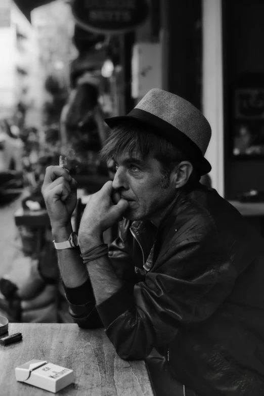 black and white pograph of man smoking a cigarette in a restaurant