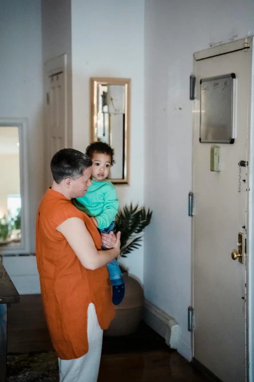 father holding his son in the hallway of the home