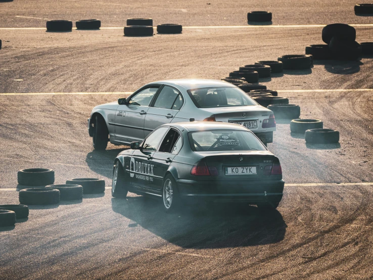 two cars are traveling along the dirt track