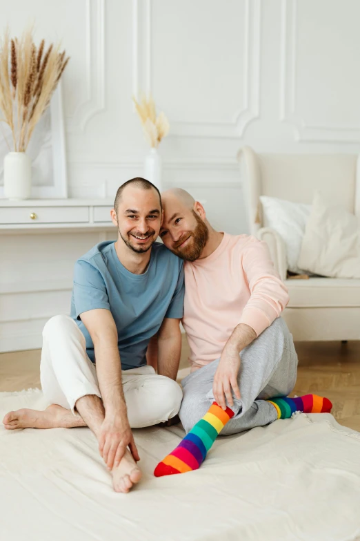 two men are sitting next to each other on a carpet