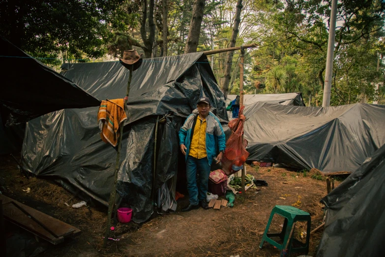 a woman standing outside of a group of tents