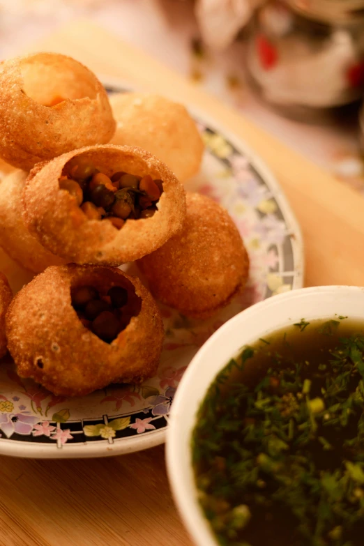 food items are on a plate, with green sauce in the bowl