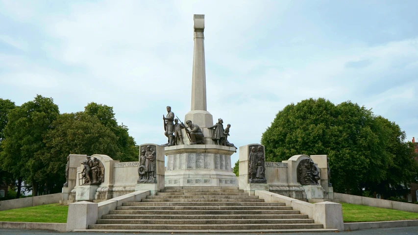 a statue of men on horses and horses sitting on the steps of a monument