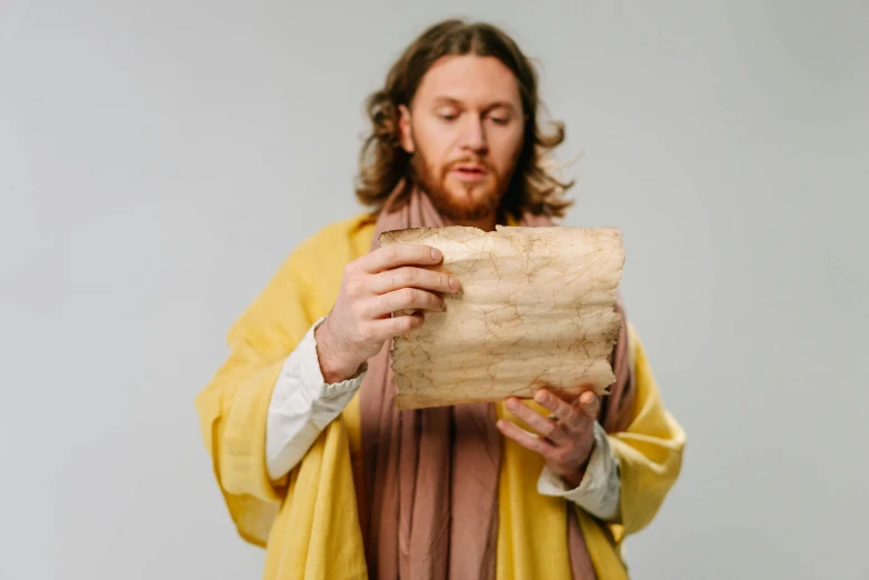 a man with long hair and a beard, holding a slab of wood