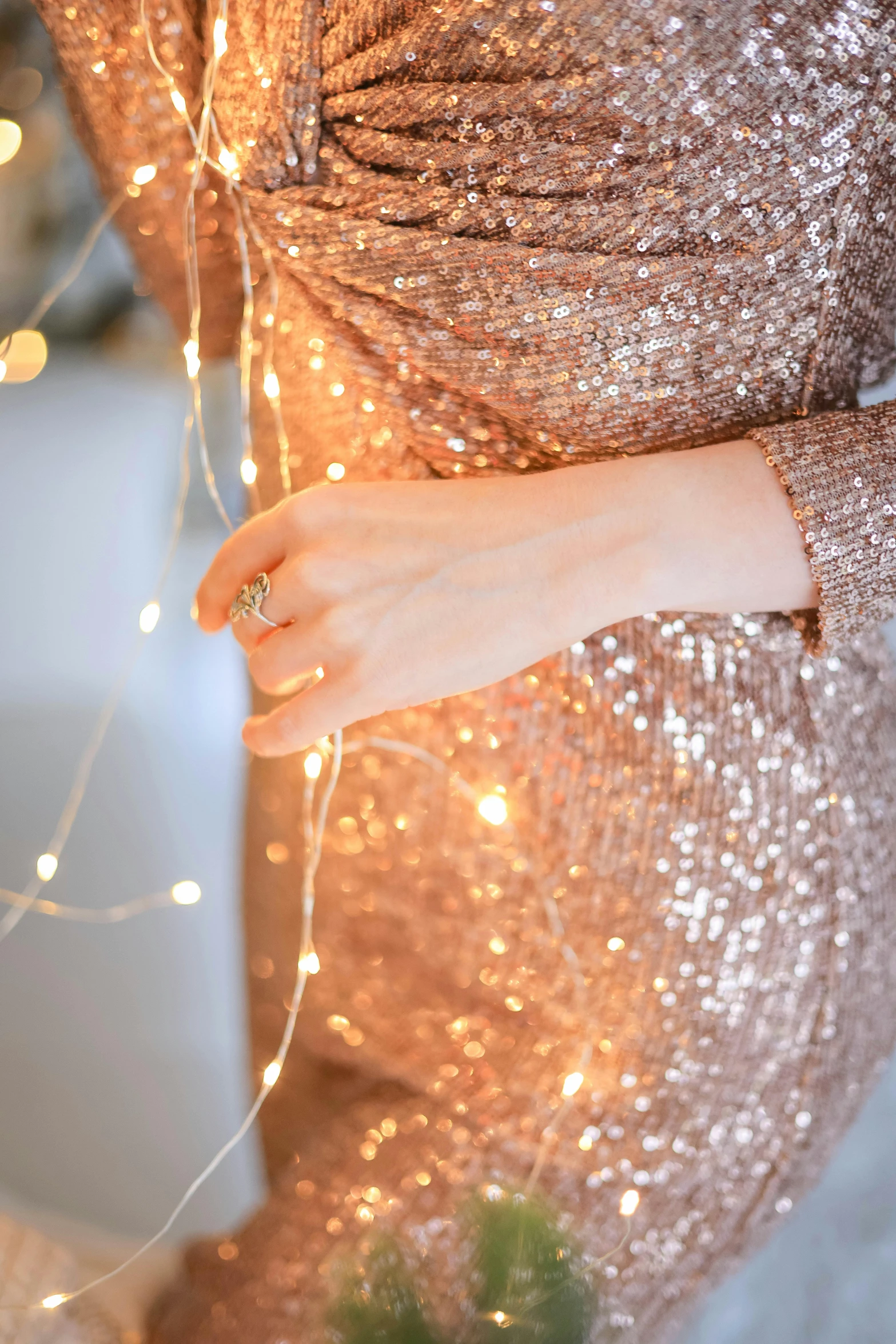 a female hand on a string attached to the ring of a light up light - garland