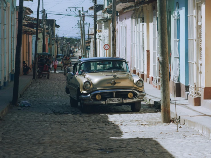 a gold car parked on a narrow street