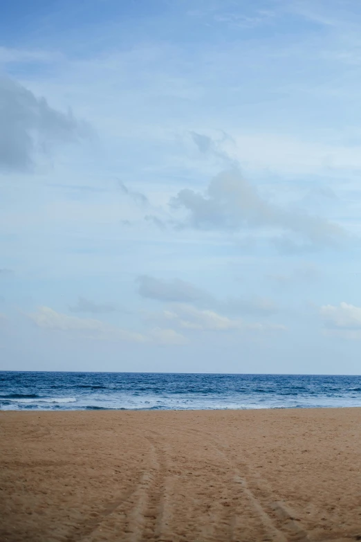 a beach area with a sand path that leads into the ocean