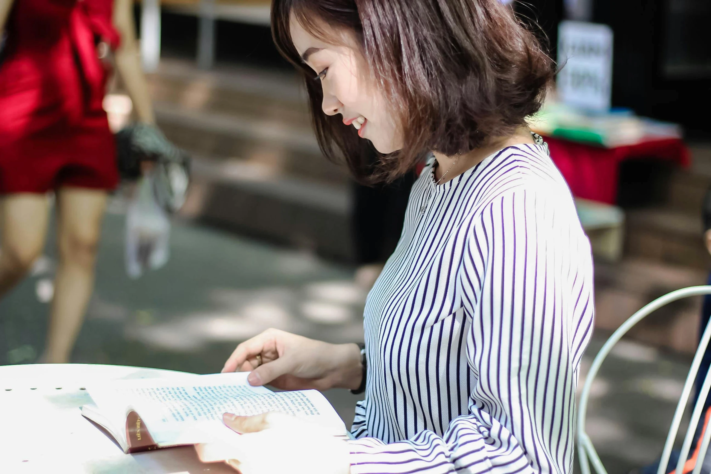 a woman sitting at a table with an open book