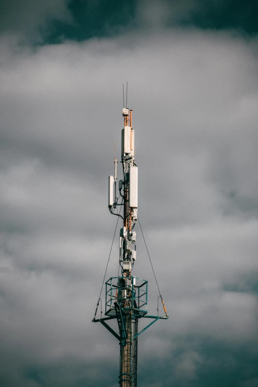 a cellphone tower with several phone lines on the top