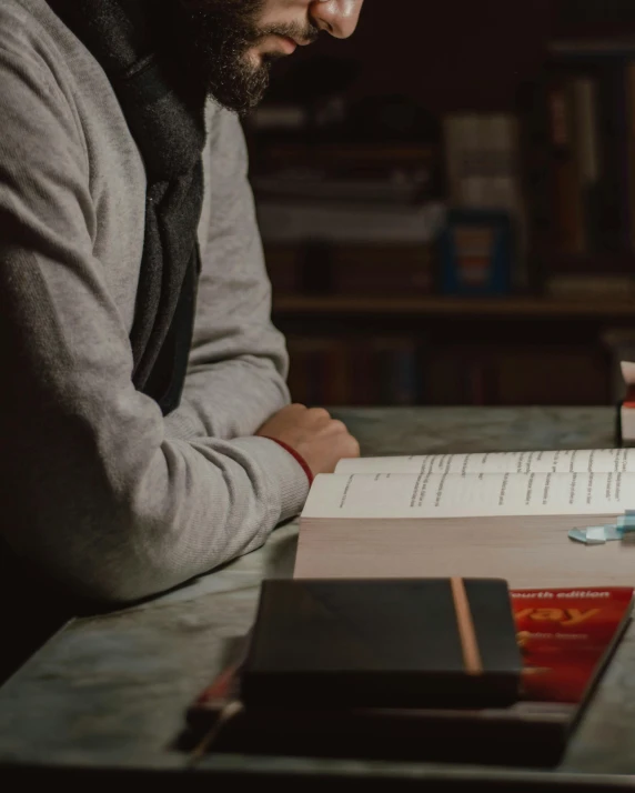 a man writing on a piece of paper at a desk