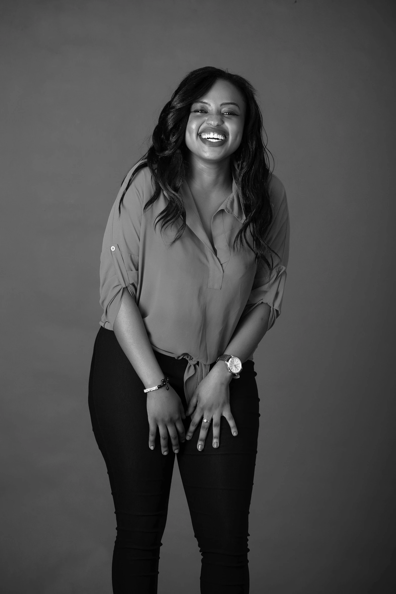 black and white image of a smiling woman in pants