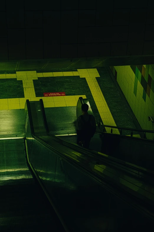 an escalator and person waiting for the train