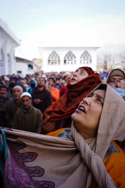 a group of people standing around each other with scarves on