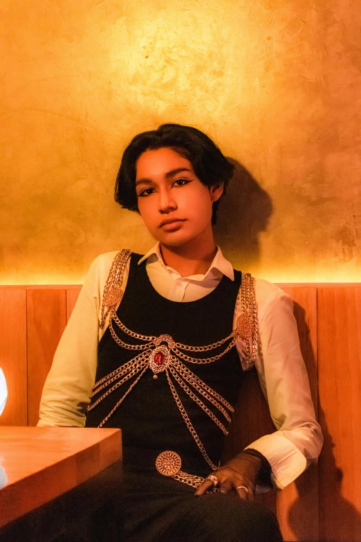 a girl sitting at a wooden table and posing