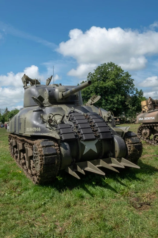 two army tanks are sitting in the grass