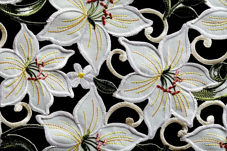 an embroidered flower with leaves and flowers on black