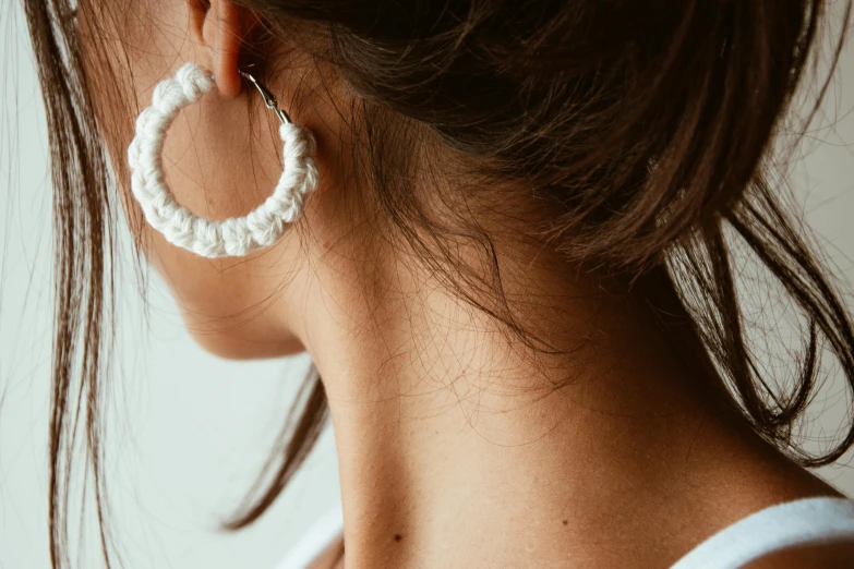 the white circle earring is attached to a white head piece