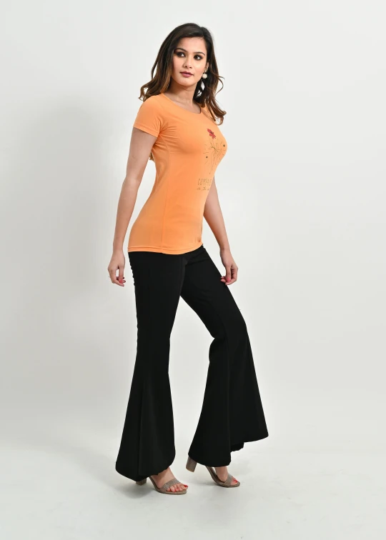 an attractive young lady in black pants and an orange t - shirt